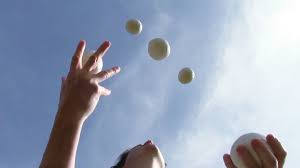 man juggles balls in air